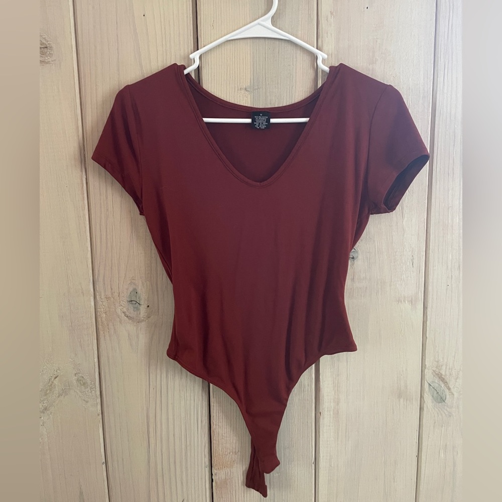 Burnt orange body suit.